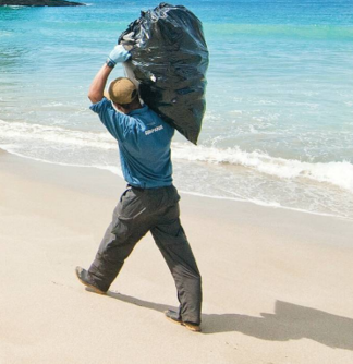 Turtle ranger carrying trash on a pristine beach