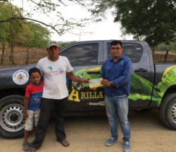 Marcos Calero delivers incentives to a family of parrot protectors in front of the parrot-adorned truck funded by Loro Parque Fundacion.